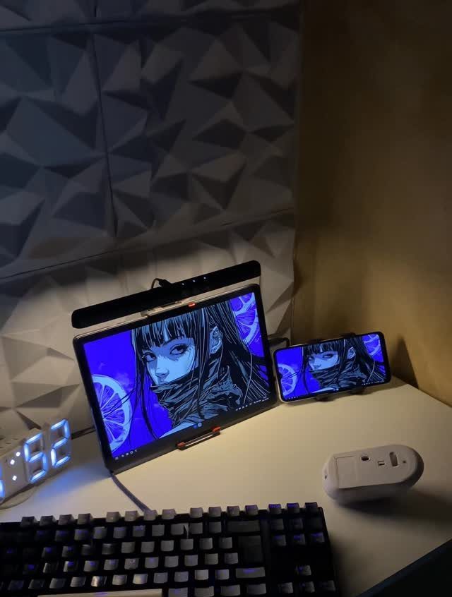 White gaming desk with tablet, keyboard, and 3D geometric acoustic wall panels.
