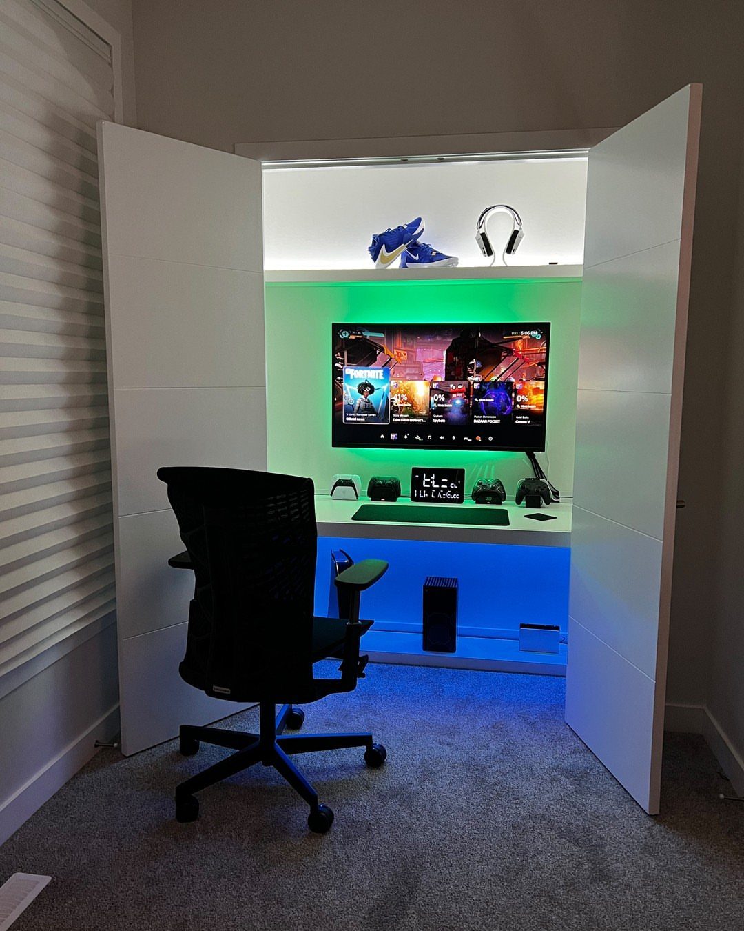 Gaming setup built into a white closet nook with blue and white LED lighting.