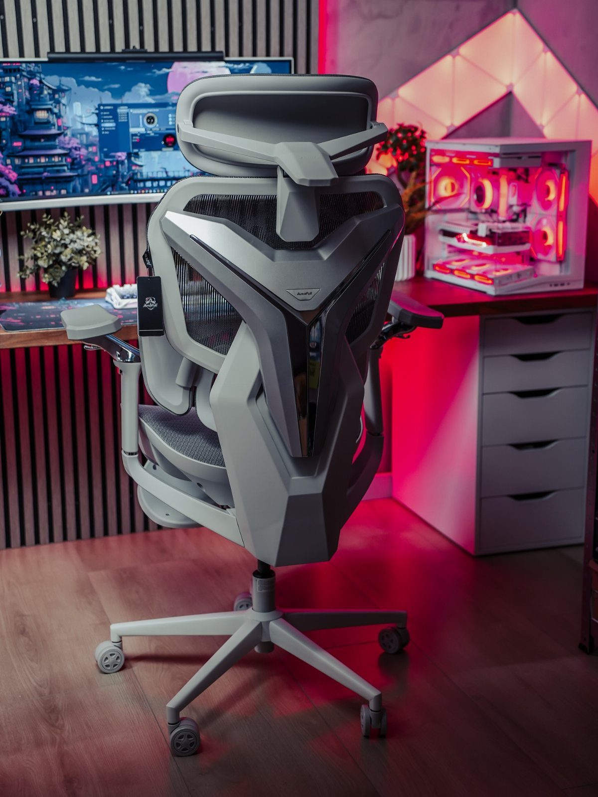 Futuristic grey ergonomic gaming chair in a room with red ambient lighting.
