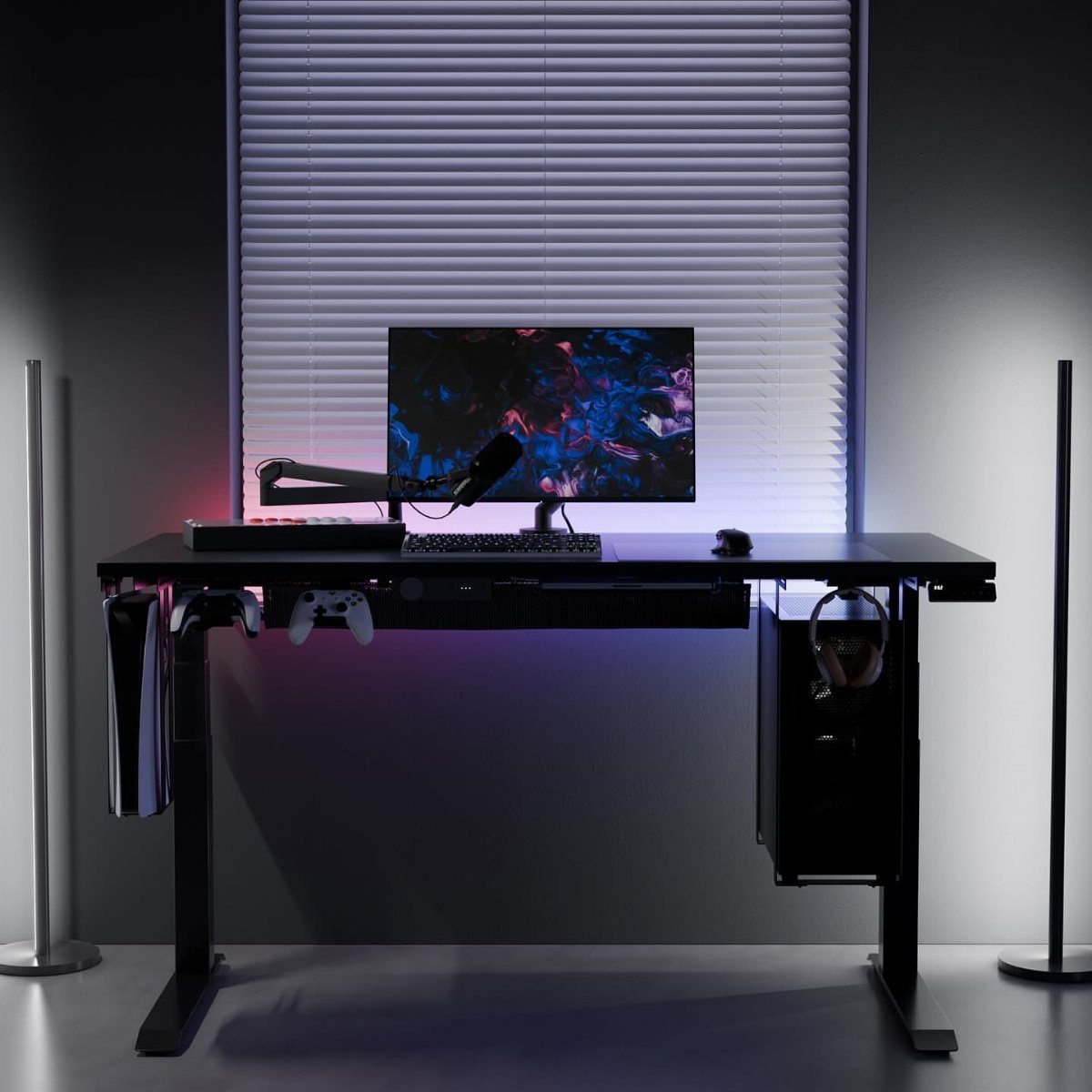 Black gaming desk with monitor arm and peripherals against a grey wall.