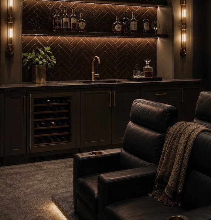 Dark home cinema room with leather recliners and a built-in bar area.