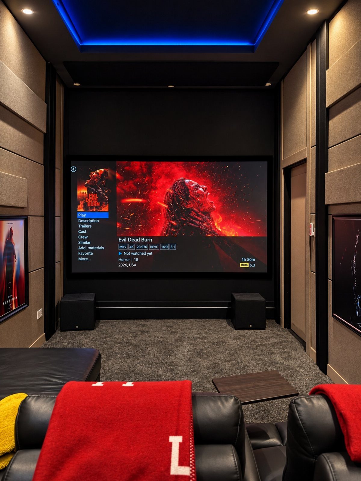 Home cinema room with large screen, blue ceiling lights, and leather recliners.