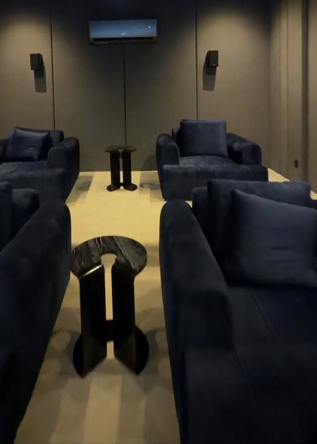 Small home cinema room with blue velvet seating and dark grey walls.