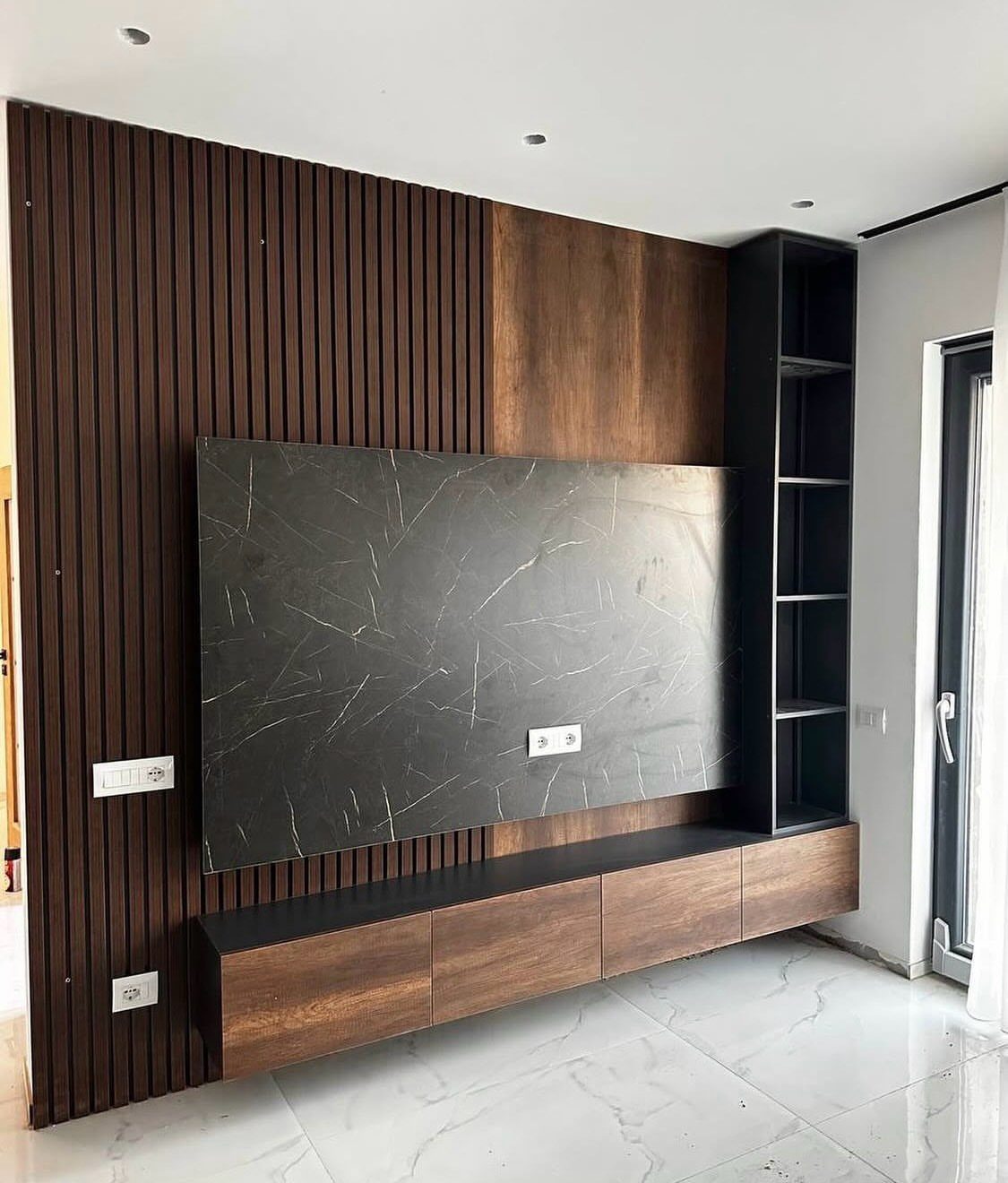Modern floating TV cabinet with matte wood finish and black marble wall panel.
