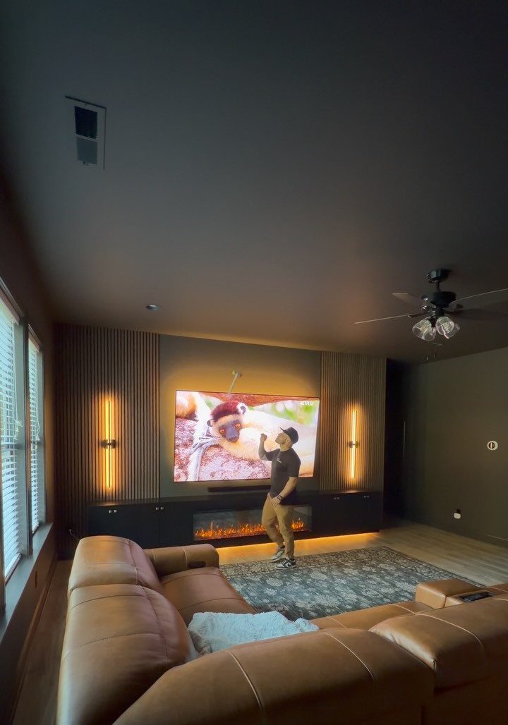 Electric fireplace console under a wall-mounted TV in a modern living room setting.