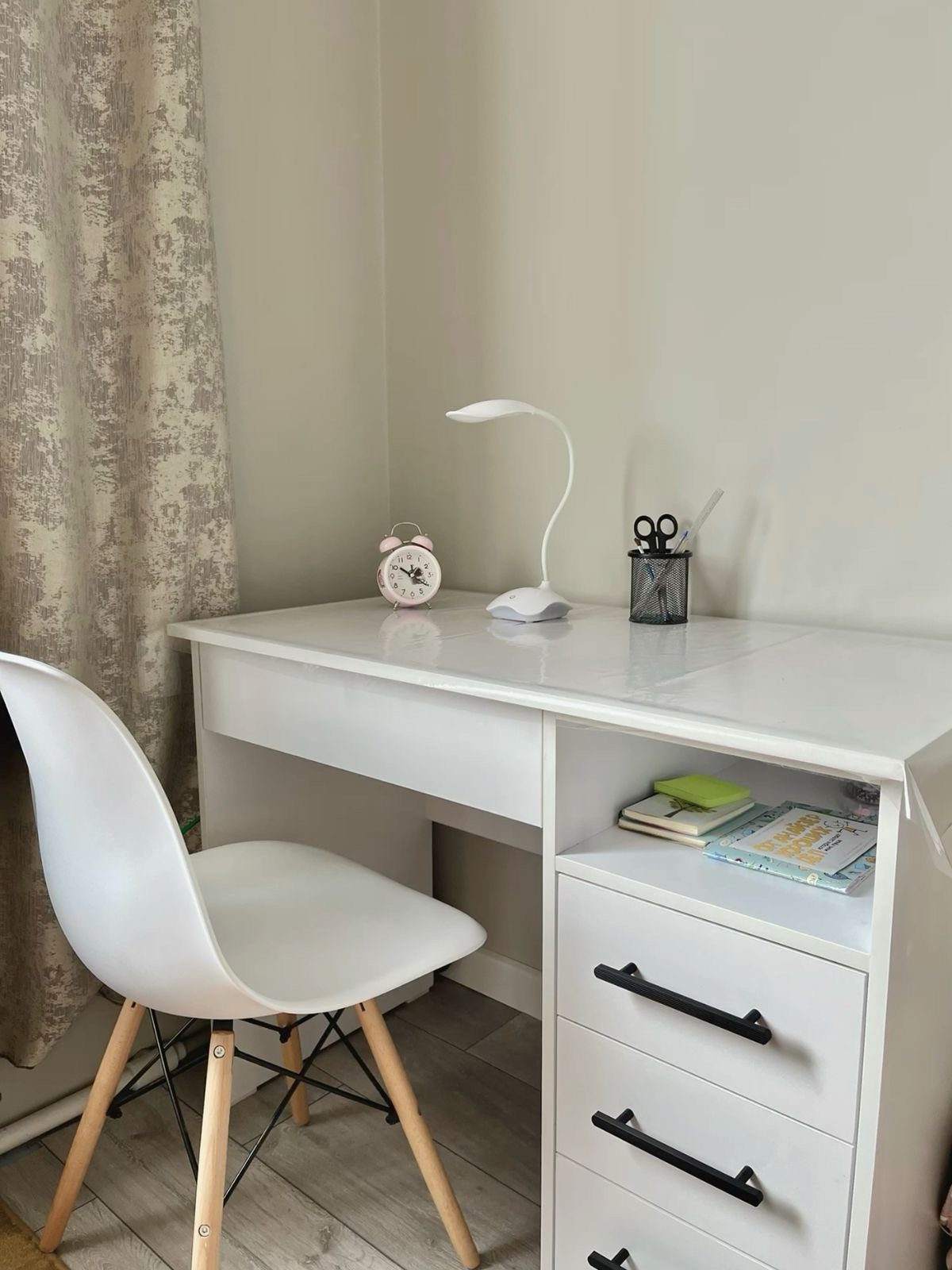 White desk with drawers and a matching chair in a bedroom setting.